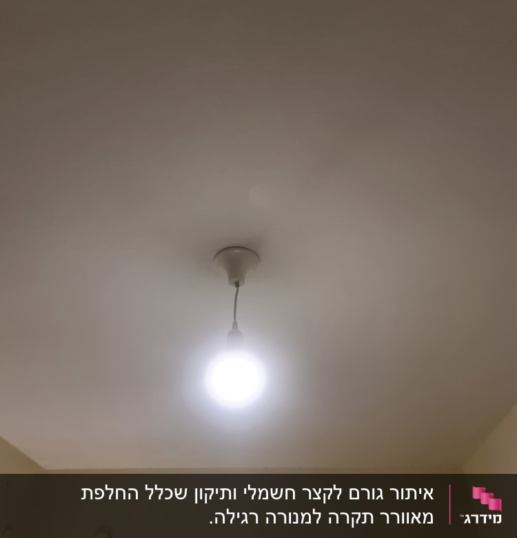 נורה חשמלית תלויה מהתקרה ומאירה את החדר